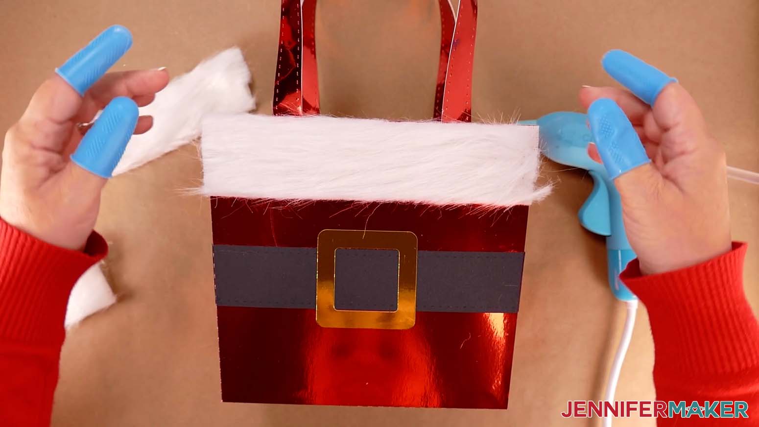 Place the fur strip onto the top edge of the Santa purse, pressing around the edges to adhere the hot glue.