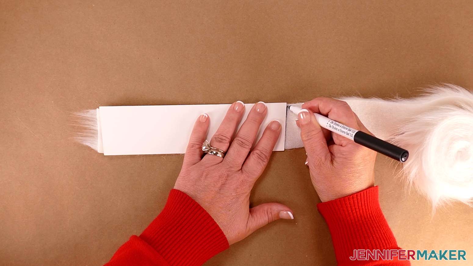 Use a dark colored pen to trace the edges of the cardstock pattern onto the fur trim for the Santa purse.