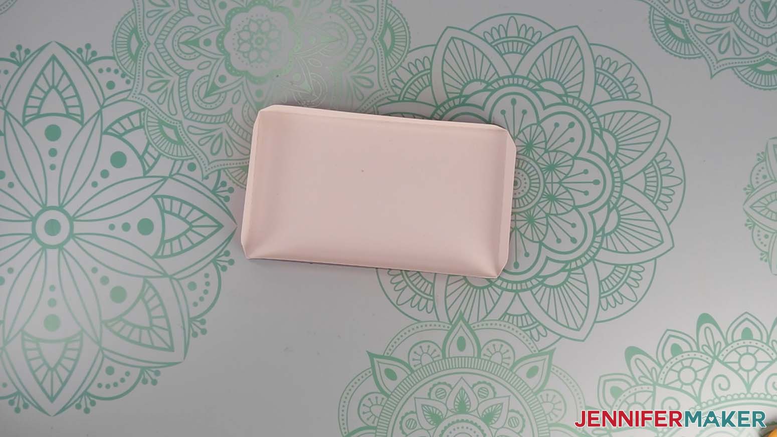 The folded Santa purse base on the work surface, pretty side down, with the short sides on the left and right.