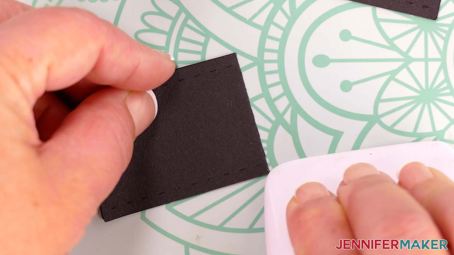 Use a scraper to sharpen the fold on the short belt piece for the Santa purse gift bag.