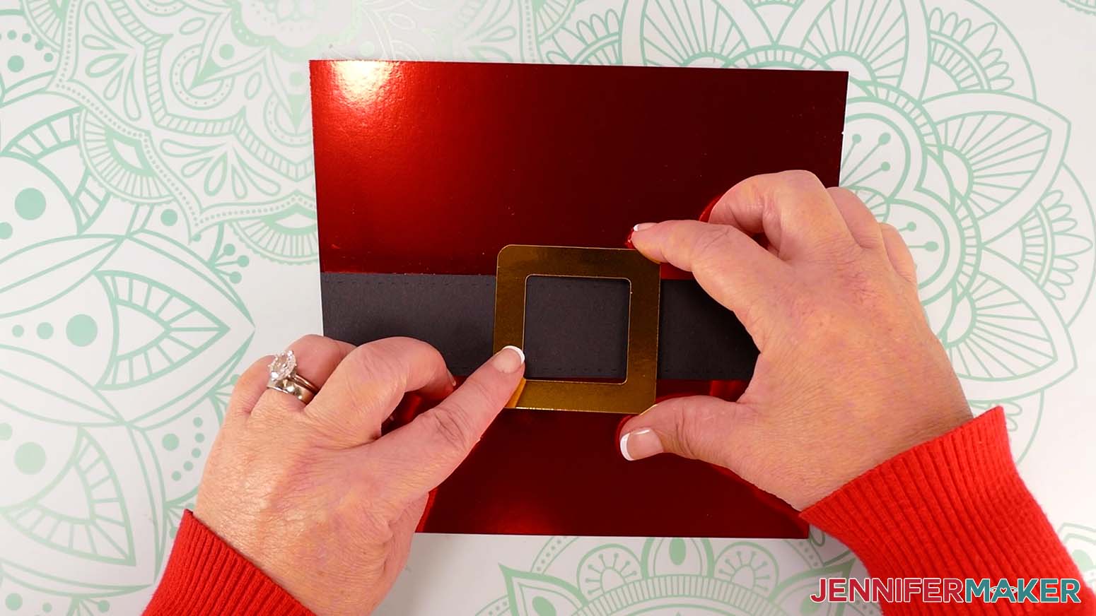 Position the gold buckle over the center of the Santa purse&rsquo;s front strap.