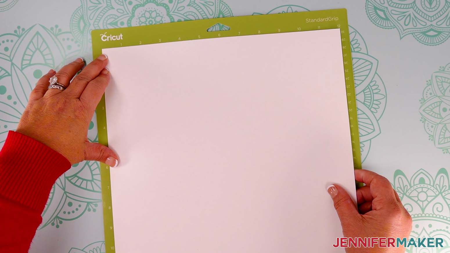 White cardstock on a green StandardGrip Cricut machine mat.