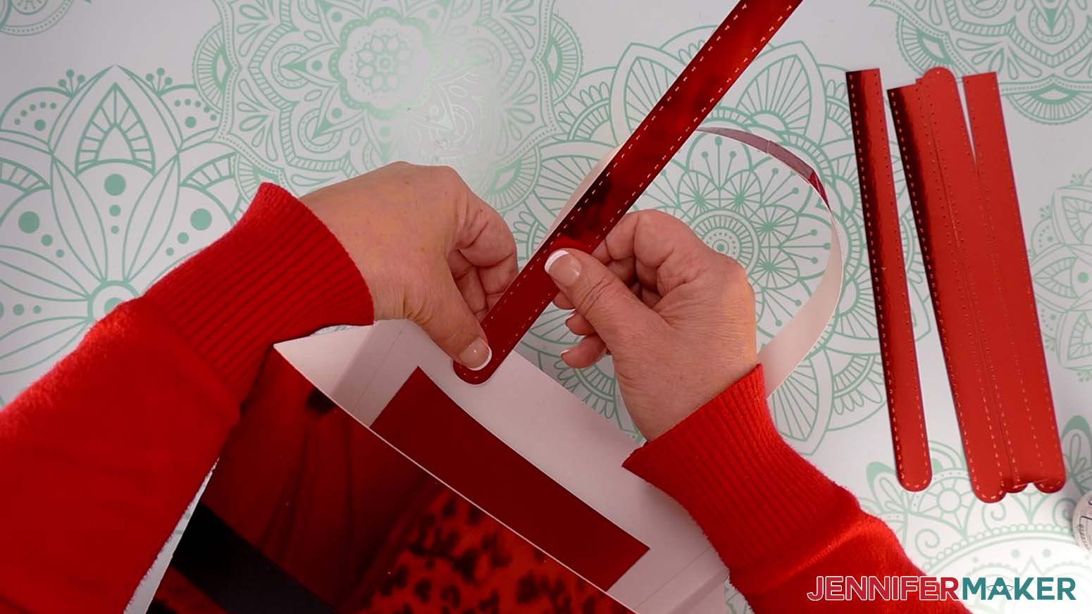Attach a handle piece to the Santa purse&rsquo;s inside left corner, aligning its rounded end with the attached handle&rsquo;s rounded end on the outside of the purse.