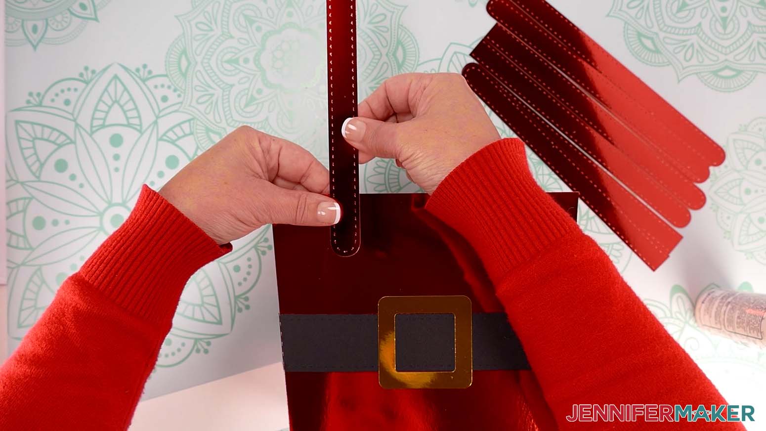 Attach the first handle piece to the Santa purse&rsquo;s top left corner.