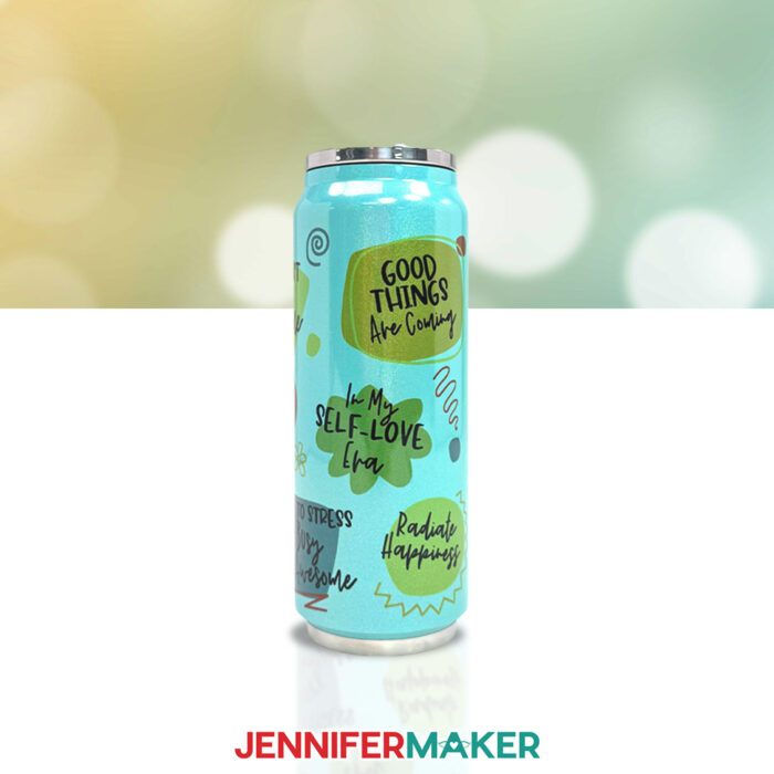 Learn how sublimation on colored tumblers works with this tutorial by JenniferMaker! A blue drinking tumbler sits on a table. The tumbler's design has several positive affirmations on colored shapes, including "Good things are coming" on orange and "In my self-love era" on green.