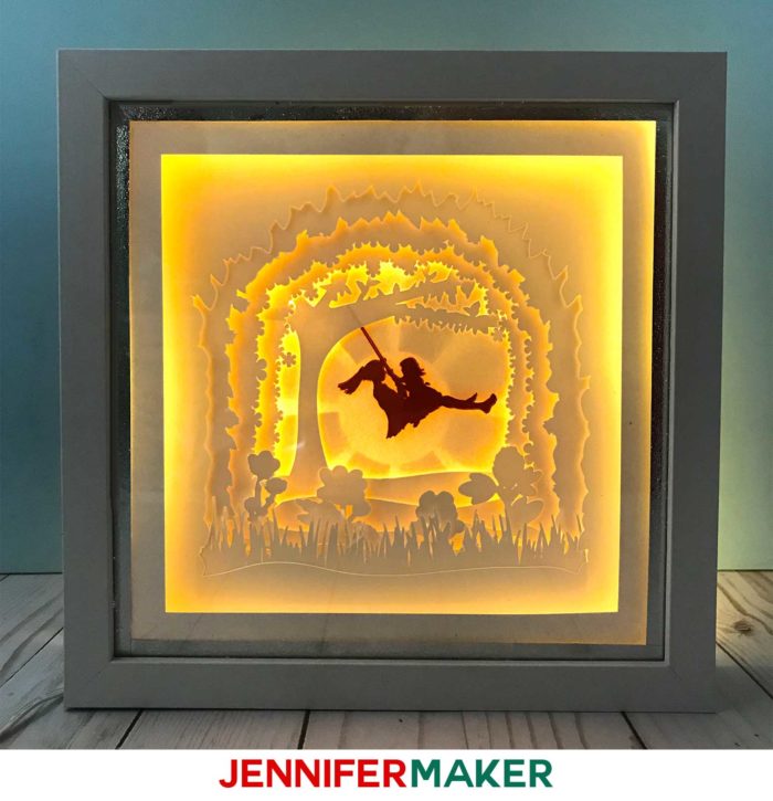 A lighted shadow box paper art template of a mother and daughter on a tree swing
