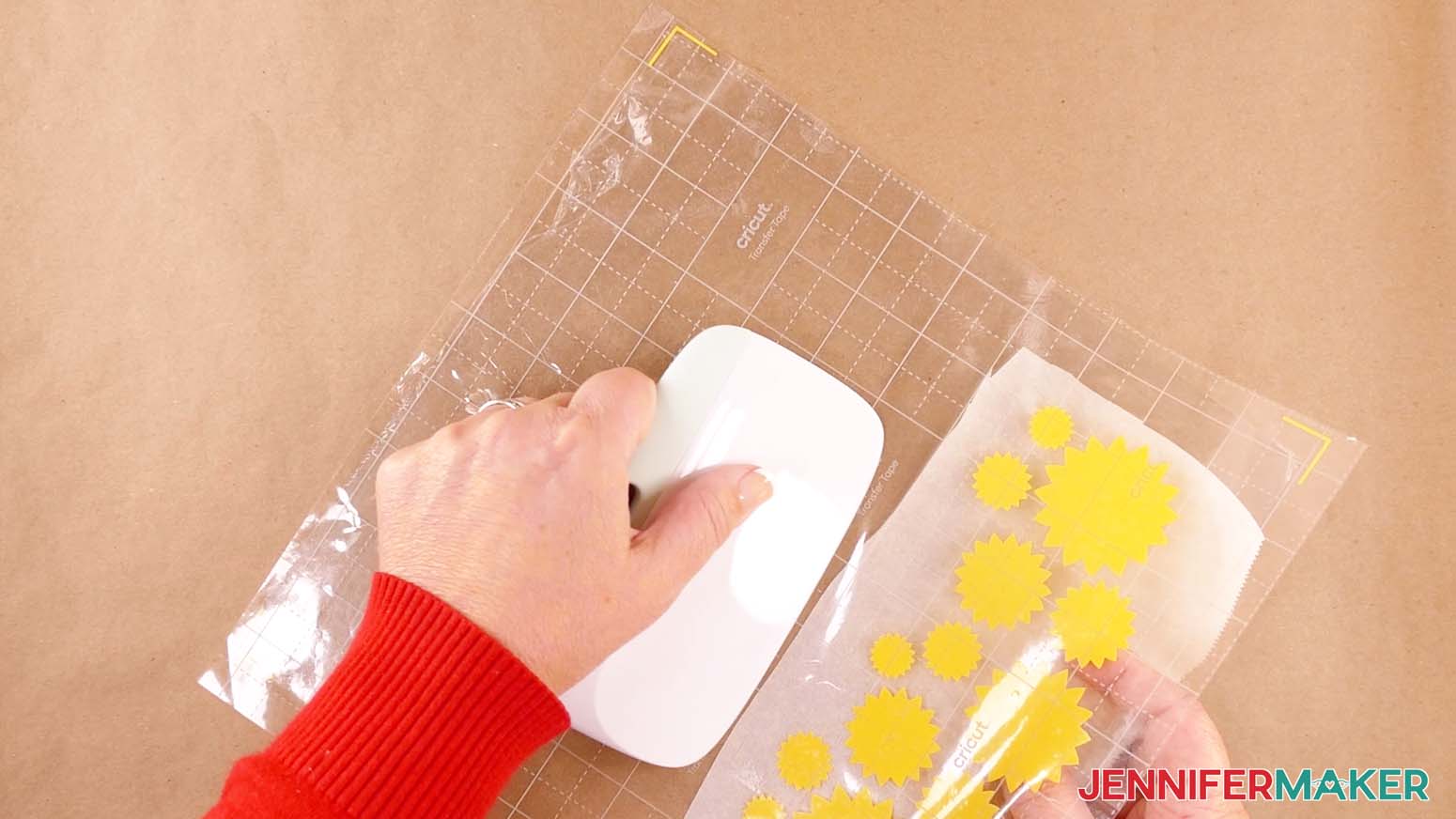 Remove the parchment paper from the vinyl design as it is applied to the acetate to make a shadow box with floating pieces