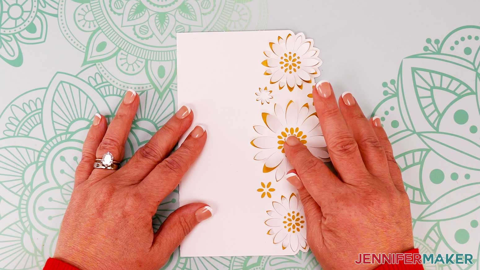 Press down in the center of the flowers to adhere them to the glued liner for the flower shaped edge card