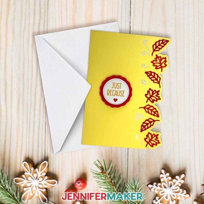 Learn how to design side edge cards with Jennifer Maker's tutorial! A beautiful card with fall leaves and decorative edges sit on a holiday table.
