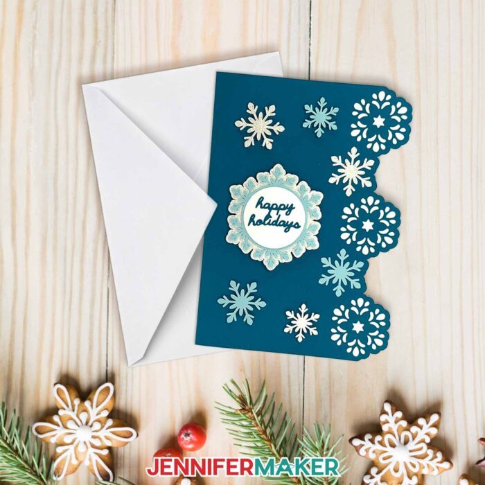 Learn how to design side edge cards with Jennifer Maker's tutorial! A beautiful card with snowflakes and decorative edges sit on a holiday table.
