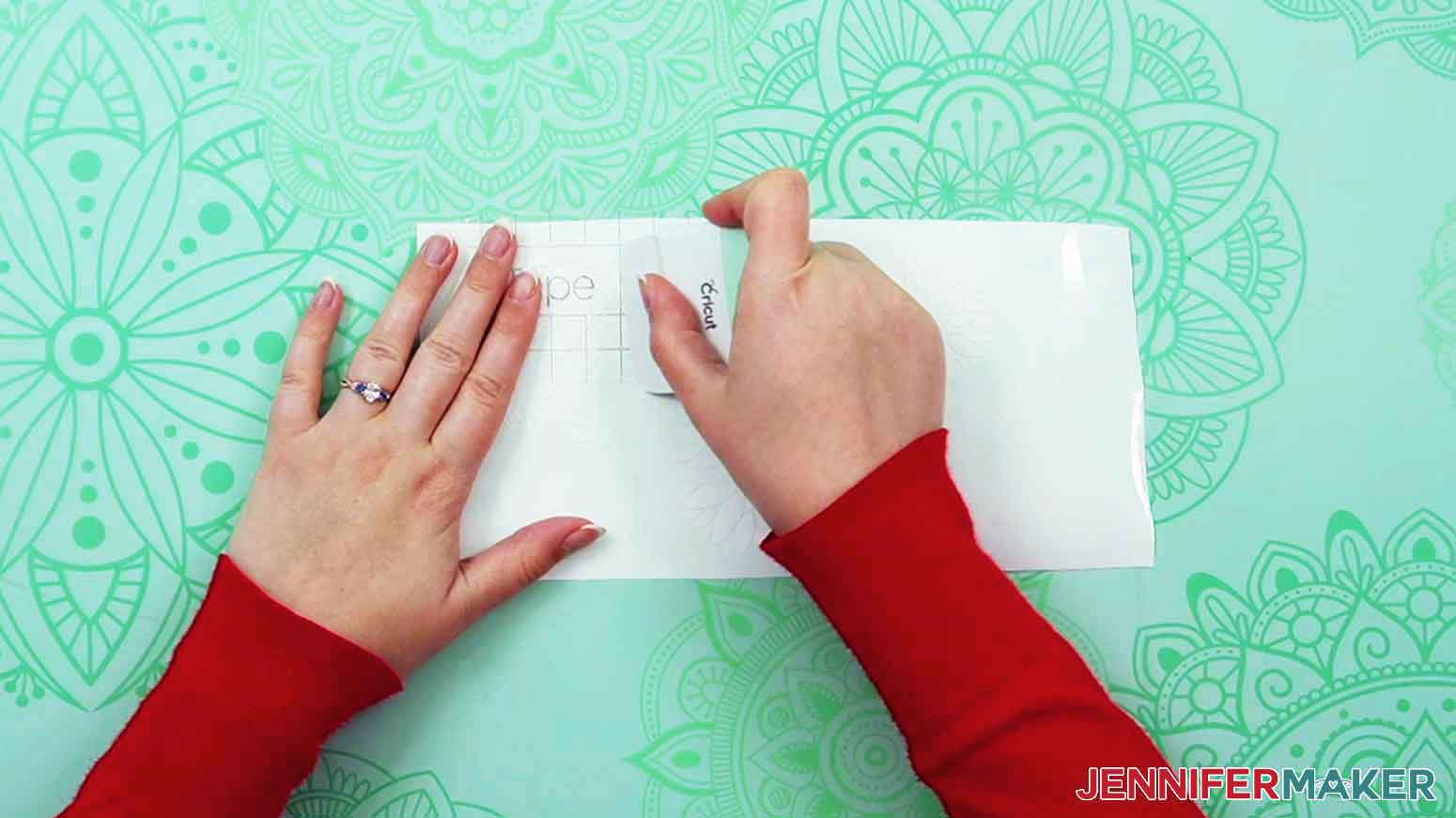 Use a scraper tool to burnish the transfer tape the the white permanent vinyl dahlia decal.