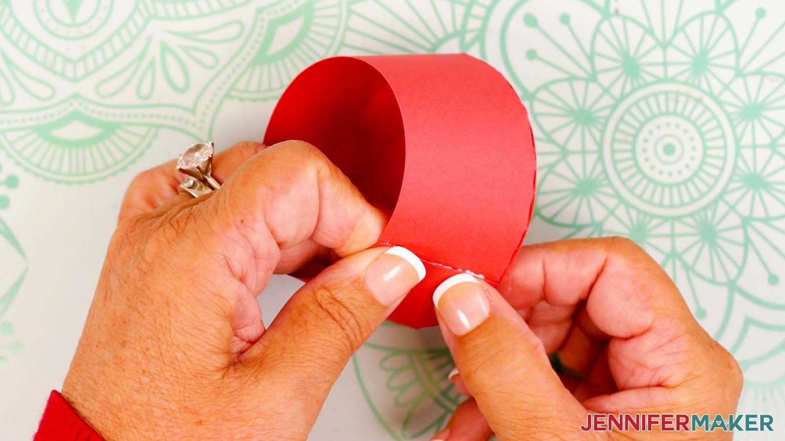 Slide in the final tab and line up the base piece’s opposite edge flush with the side tab’s crease line, then press and hold to adhere both tabs.