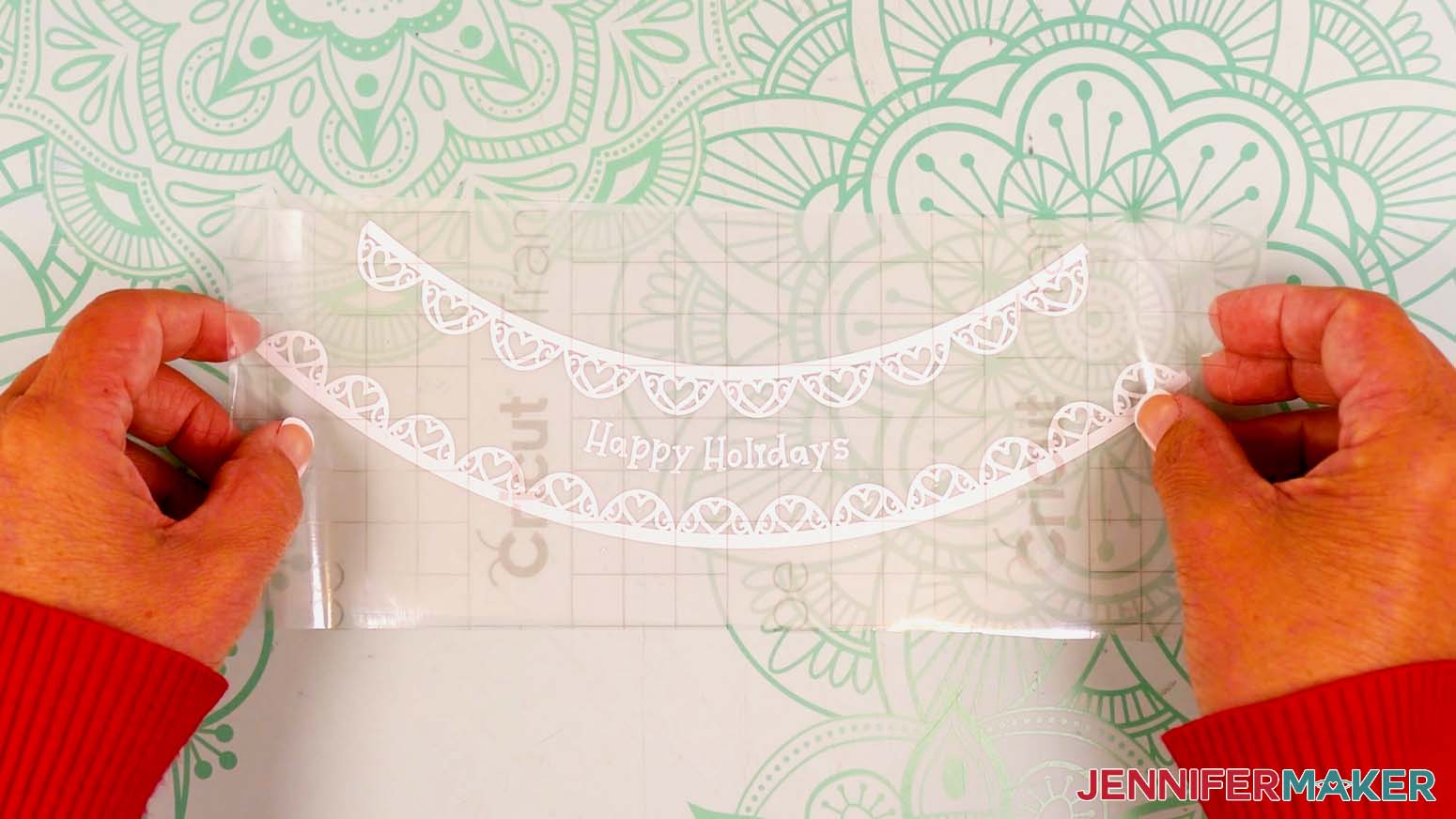 Hold the transfer tape in the shape of a “taco,” sticky side down, then center the bottom of the “taco” onto the middle of the vinyl decal.