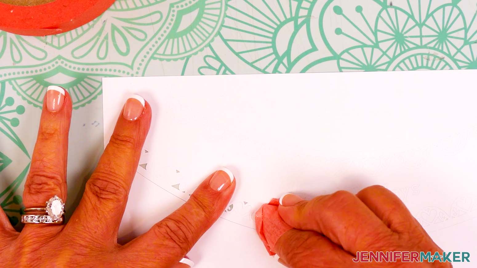Use a small piece of painter&rsquo;s tape to carefully pull away the small bits of vinyl inside the snow globe gift box design.