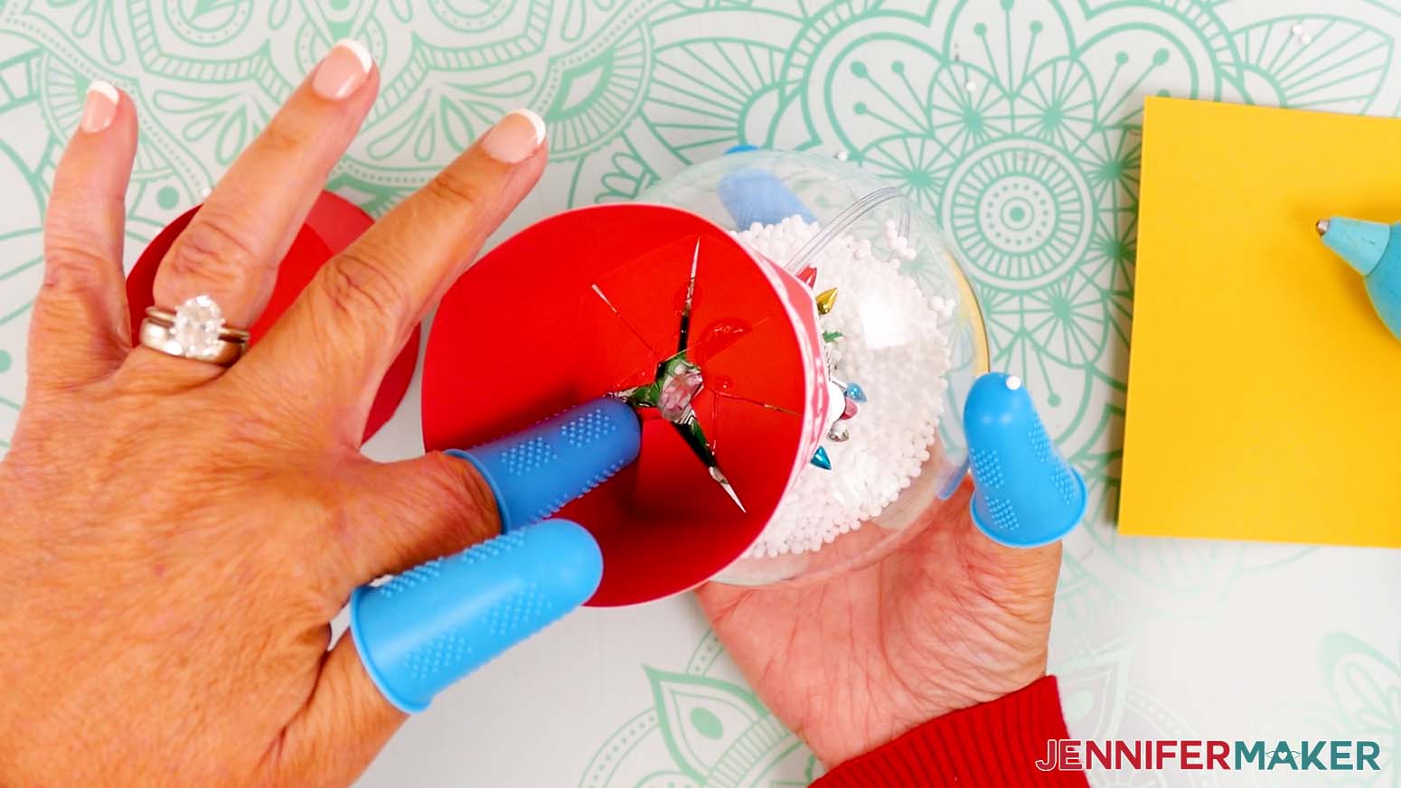 Flip over the snow globe gift box and press the glued tabs onto the bottom of the globe to adhere them together.