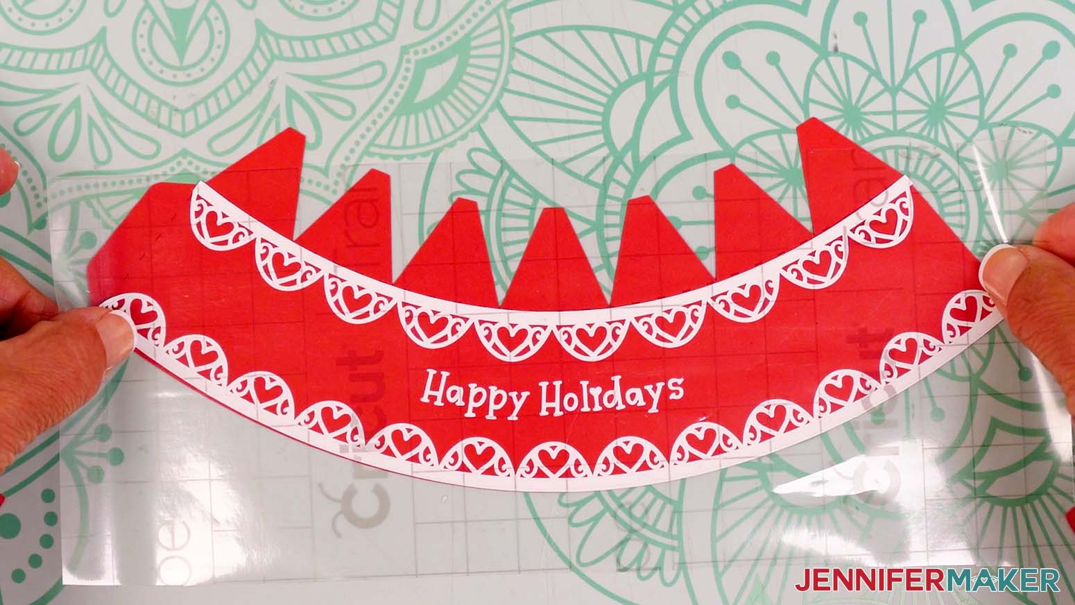 Hold the transfer tape and snow globe gift box decal sticky side down and lightly center it on the lid piece, with the top of the design directly under the tab crease lines.