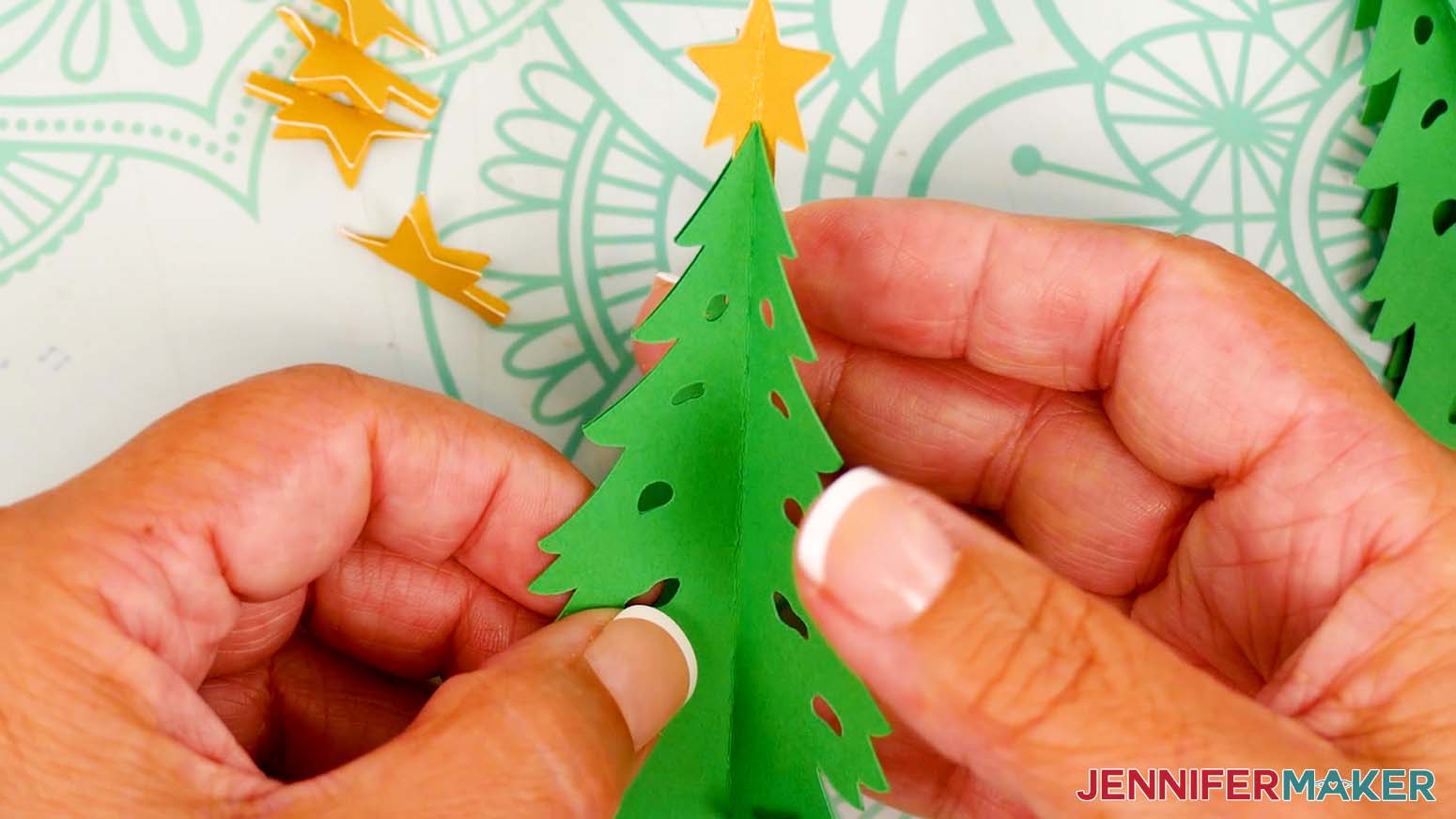 Adhere one half of the next tree piece back to back with the tree attached to the star, sandwiching the star piece in between.