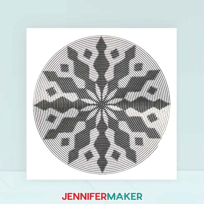 A white canvas with an intricate geometric cut vinyl design made with Sprial Betty.