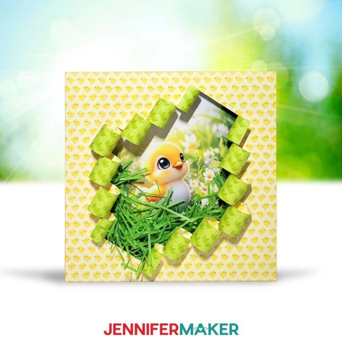 A Spring Busted Canvas project sits outside, covered in patterned spring paper, cut to reveal a cute AI-generated baby chick image. 