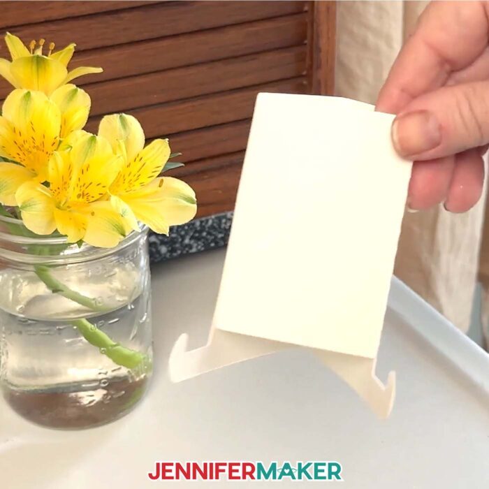 A white cardstock stand for a stacked desktop calendar.