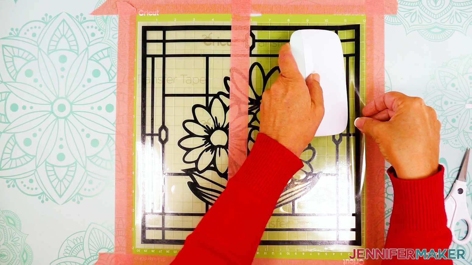 Use an extra large scraper to burnish the vinyl onto the acetate layer of the stained glass design.