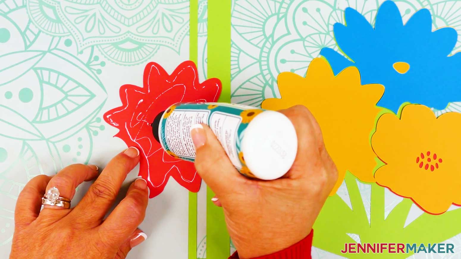 Place glue on the back of the upper flower piece to apply it to the matching back flower piece of the stained glass design.