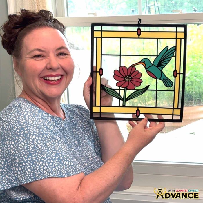 Make Stained Glass Using Paper! Jennifer Maker holds a custom paper, acetate, and vinyl stained glass window-inspired craft she designed in the ADVANCE by JenniferMaker program
