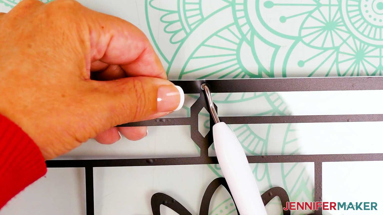 Use the weeding tool to poke a hanging hole through the acetate layer of the stained glass design.