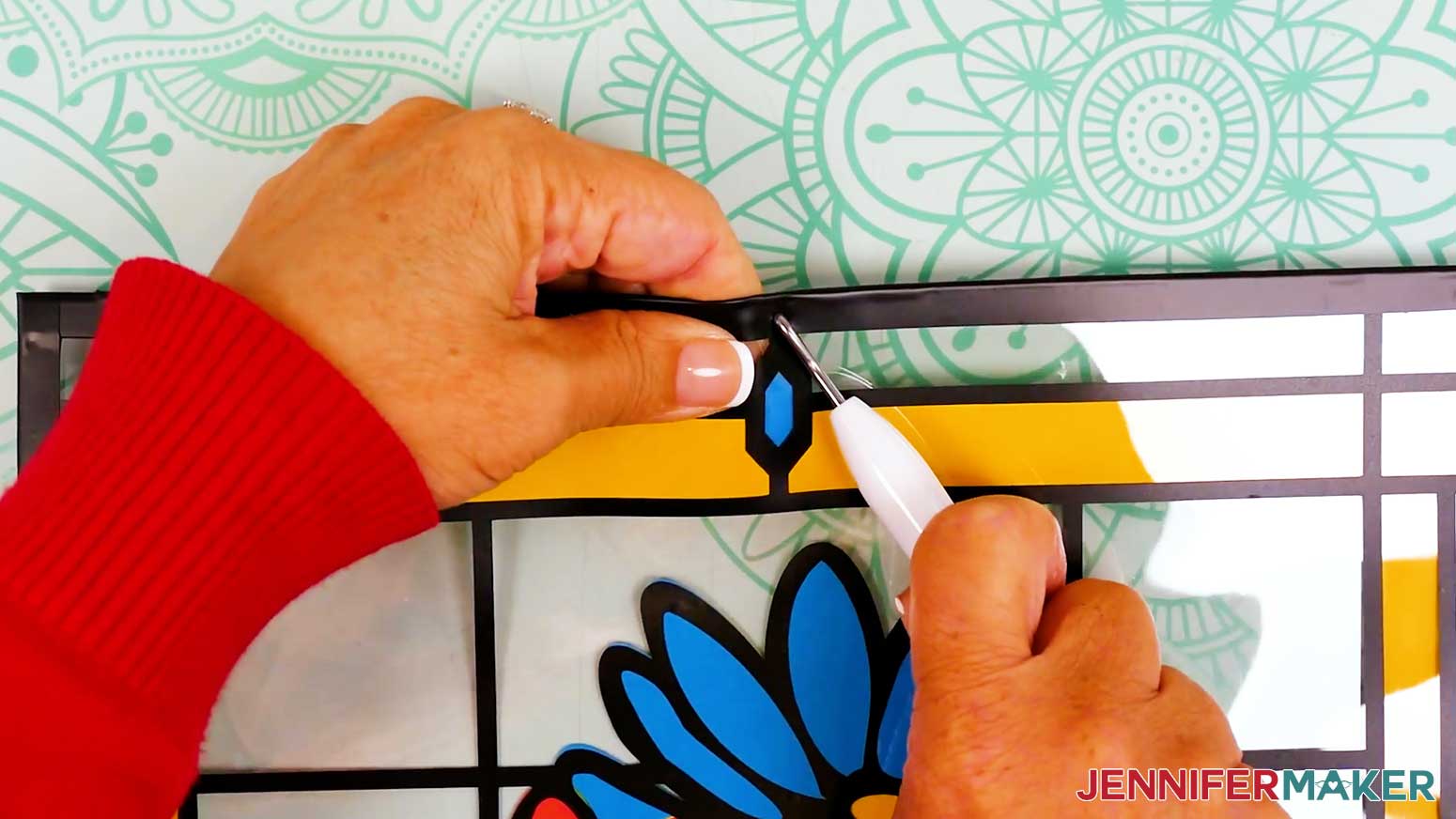 Use the weeding tool to poke a hole through the layers of vinyl tape on the top of the stained glass design.