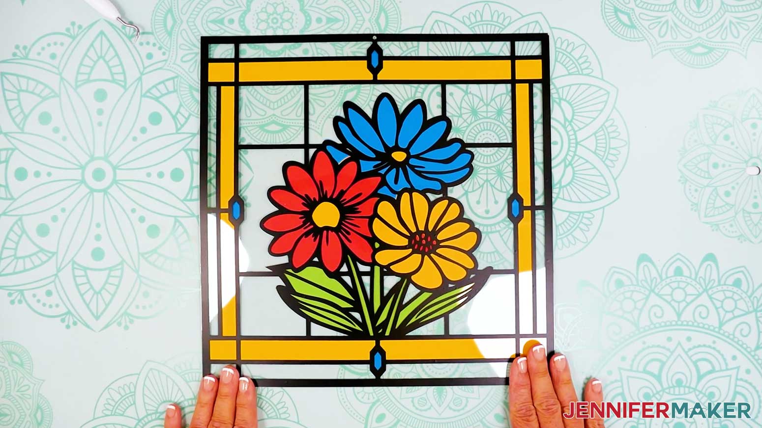 Adhere the upper layer of acetate and black vinyl to the cardstock layers of the stained glass design.