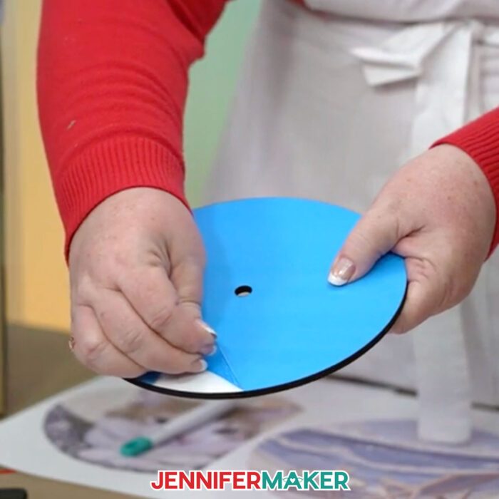 Peeling back the blue protective film from a clock sublimation blank.
