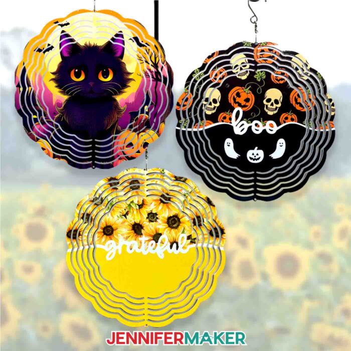Learn how to sublimate a wind spinner with Jennifer Maker's tutorial! Three wind spinners hang in front of a field of sunflowers: a spooky Halloween black cat spinner; a spinner with the word "boo" surrounded by pumpkins, skulls, and ghosts; and a yellow spinner with sunflowers with the word "grateful."