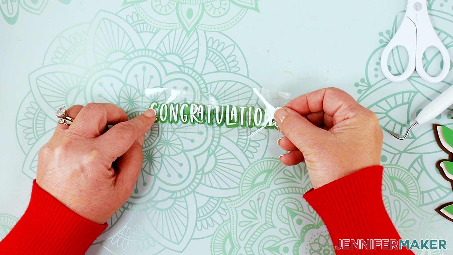 Apply the white vinyl congratulations works to the green offset cardstock layer.