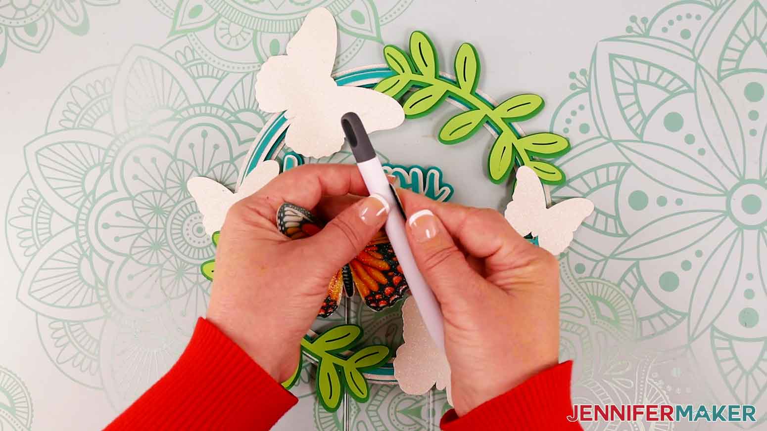 Use the handle of a weeding tool to shape the sublimated glitter cardstock butterflies.