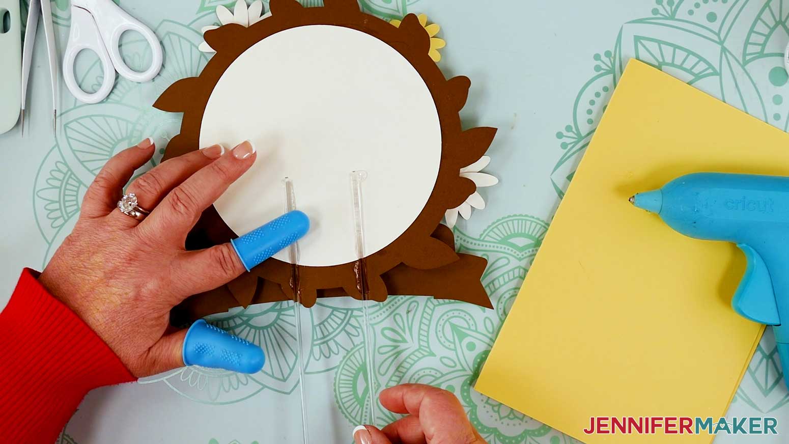 Use a hot glue gun to attach the clear acrylic sticks to the back of the cake topper.