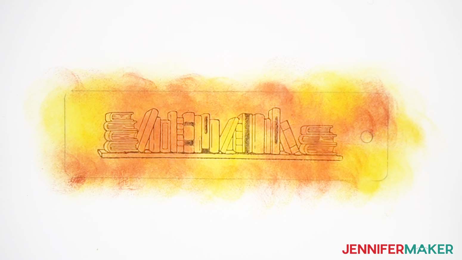 A bookshelf stamp with black ink applied to the orange and yellow ink already on the paper.