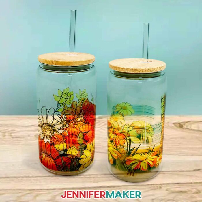 Learn how to make a sublimation beer can glass with Jennifer Maker's tutorial! Two beautiful sublimated beer can glasses featuring floral and beach images sit against a blue background.