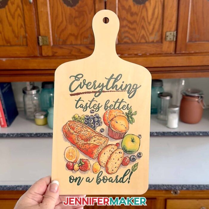 A sublimated charcuterie board with a fruit and bread design and the words "Everything tastes better on a board!"