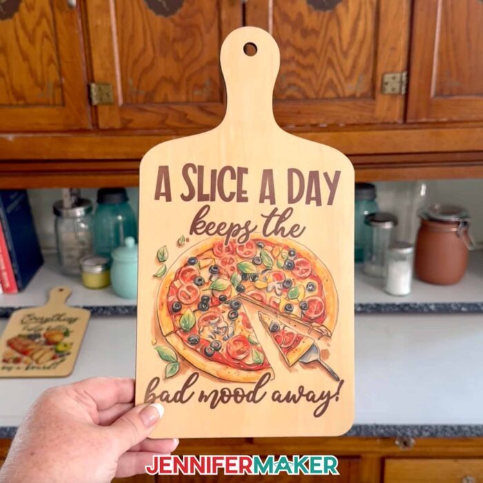A sublimated charcuterie board with a pizza design and the words "A slice a day keeps the bad mood away!"