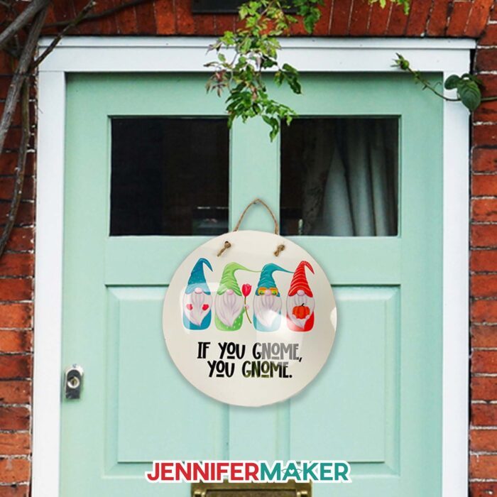A green front door with a round sign featuring four illustrated gnomes above the phrase "if you gnome, you gnome" using sublimaiton.