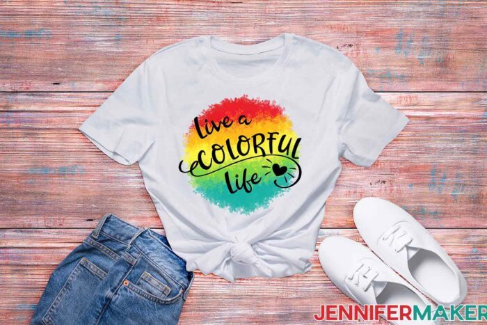 White t-shirt with rainbow sublimation design that says "live a colorful life"