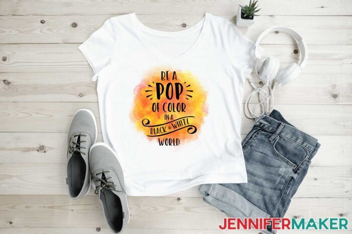 White sublimation t-shirt with orange and yellow color that reads "be a pop of color in a black and white world"