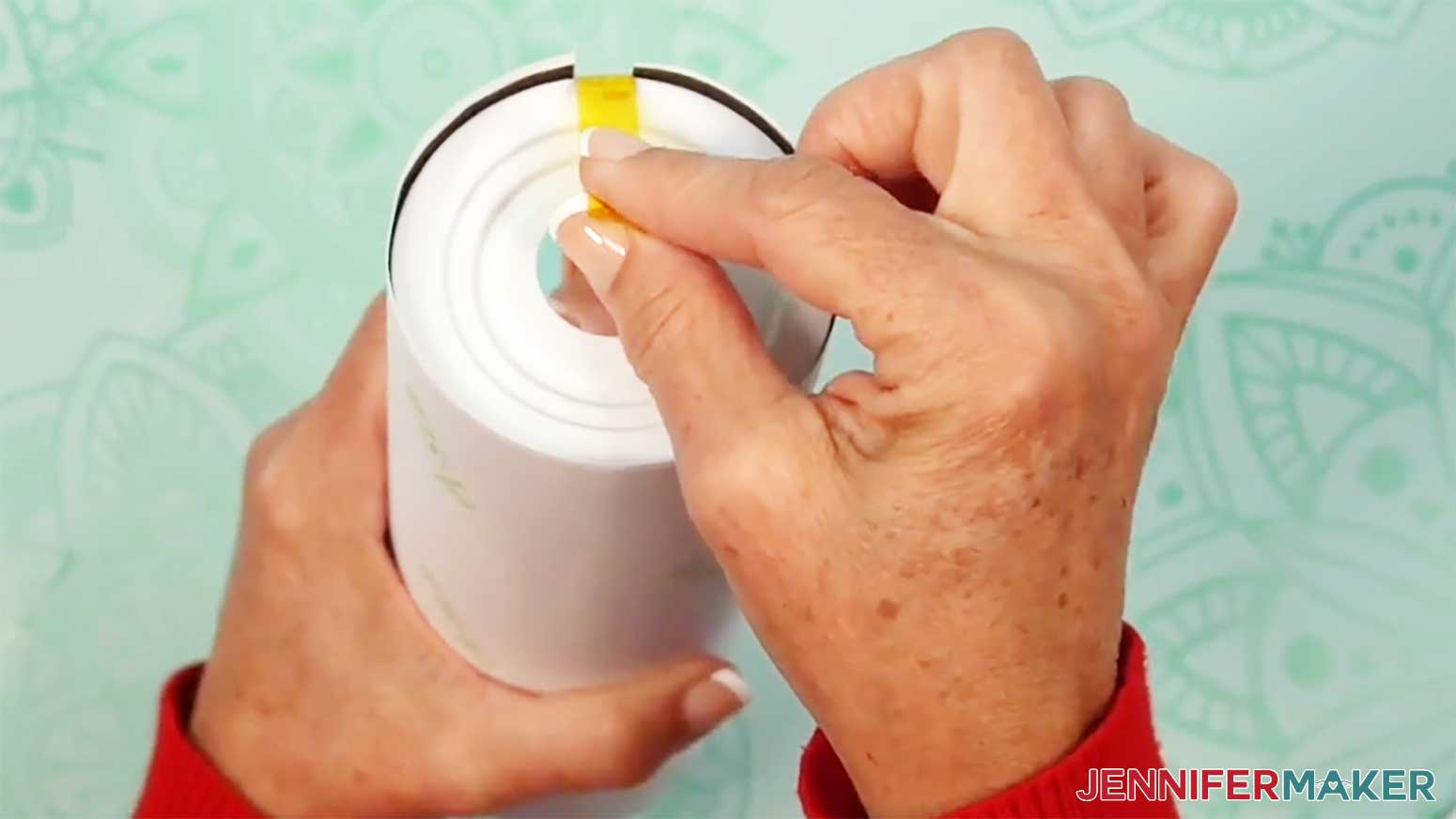 Press the piece of tape tightly onto the bottom of the glow in the dark tumbler.