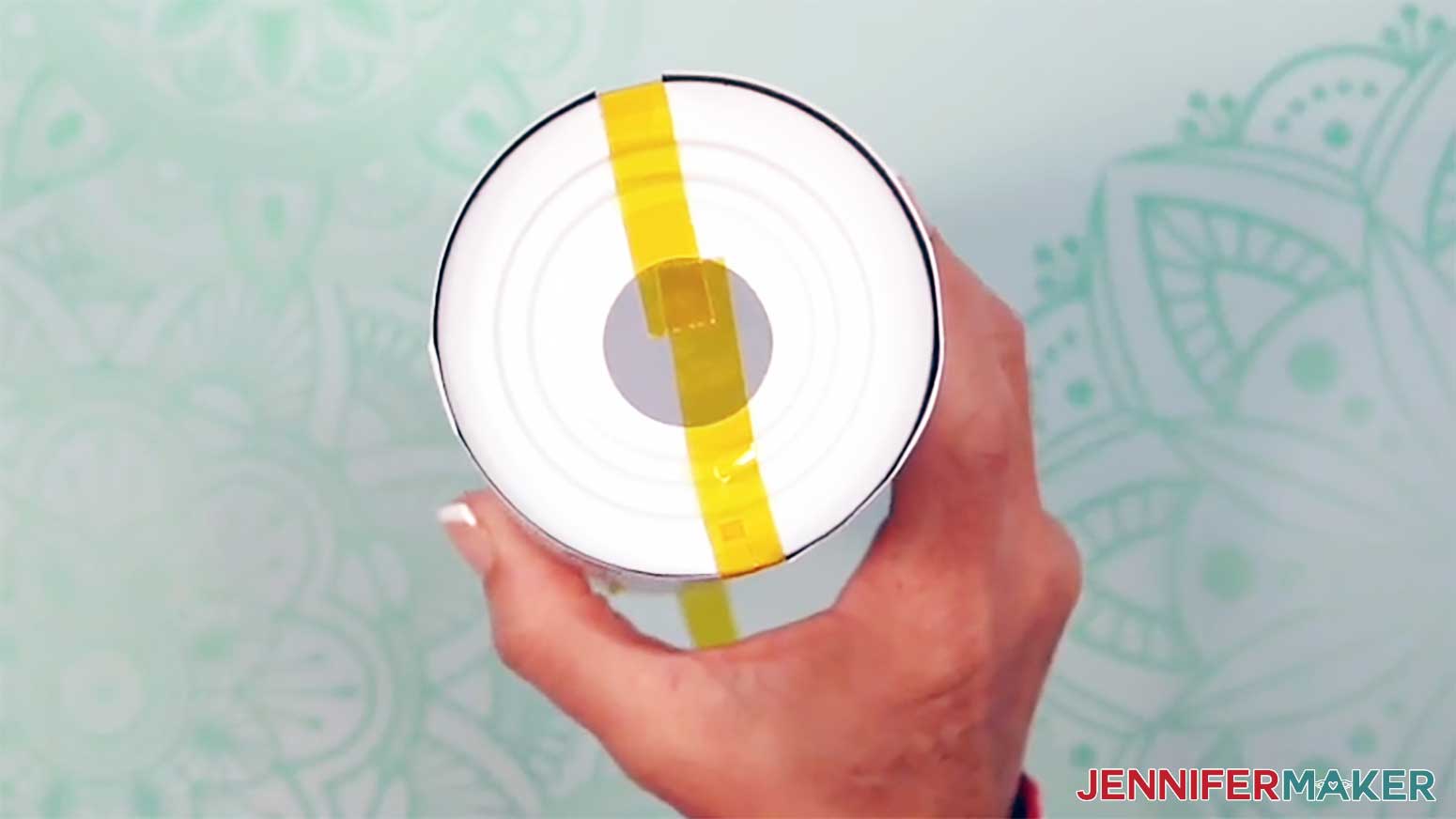 Press the next piece of tape across from the first piece on the bottom of the glow in the dark tumbler.