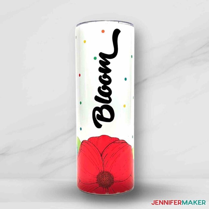 A sublimation tumbler with an illustrated red flower at the bottom and the word bloom in decorative black text.