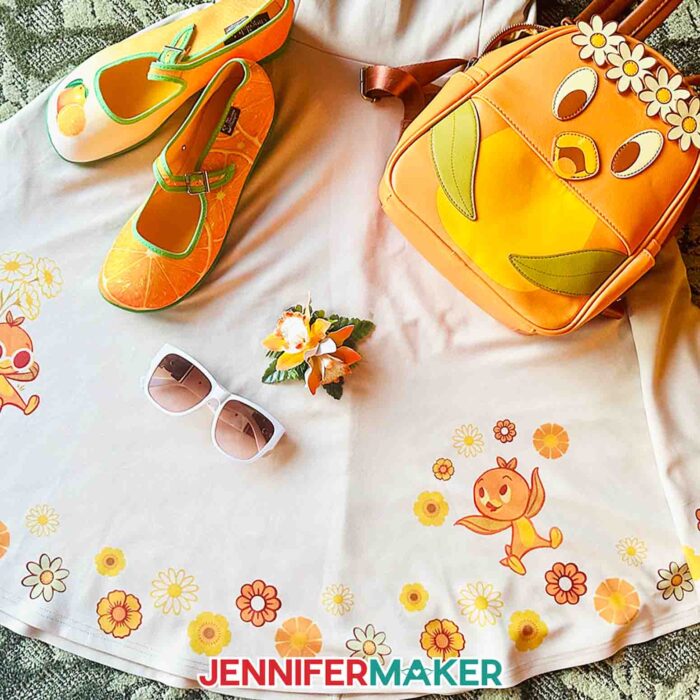 Flat laid vintage style dress with Orange Bird-inspired sublimation designs from Jennifer Maker's vacation ideas post.