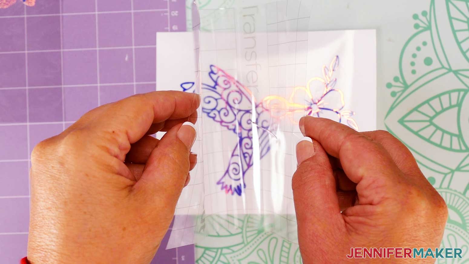 Fold the edges of the transfer tape up like a taco shape and lower the center of the design to the cling.