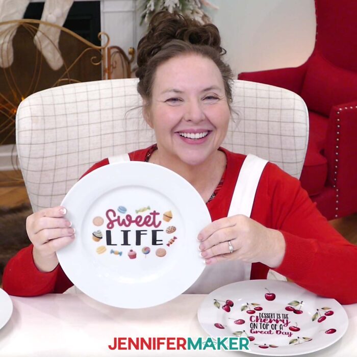 Jennifer Maker smiles and shows off a plate she decorated with waterslide decals that say "Sweet Life" as part of her Waterslide Decals For Beginners tutorial