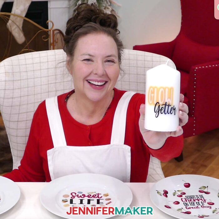 Jennifer Maker smiles and shows off a candle she decorated with waterslide decals as part of her Waterslide Decals For Beginners tutorial