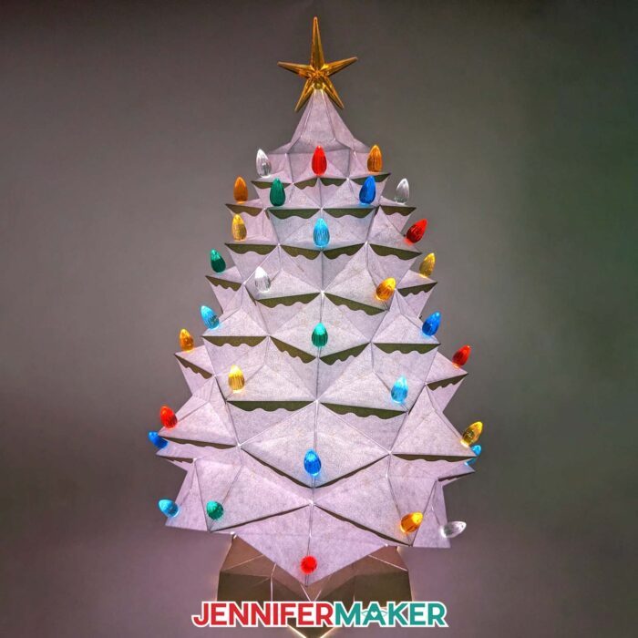 Learn how to make a light-up tabletop Christmas tree for the holidays with JenniferMaker's tutorial! An elaborate white cardstock Christmas tree glows with multicolored lights.